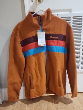 Cotopaxi Teca fleece jacket with burgundy, red, and bright blue stripes